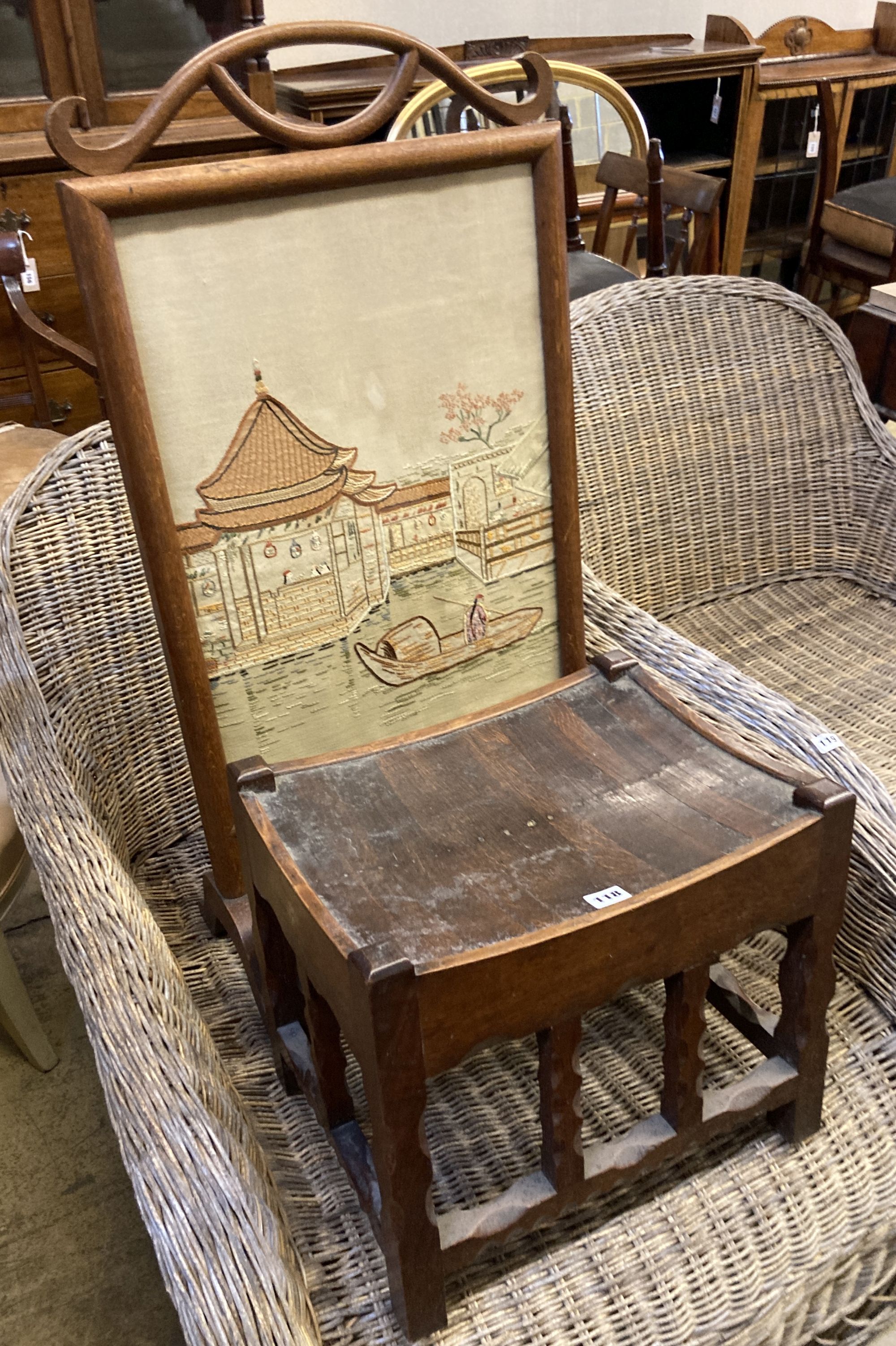 An Arts & Crafts rectangular chip carved oak stool, width 43cm, depth 34cm, height 38cm, together with an embroidered firescreen